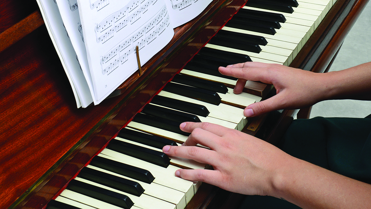 A location shot of a man playing the piano, shot in a bar environment with natural and studio lighting.